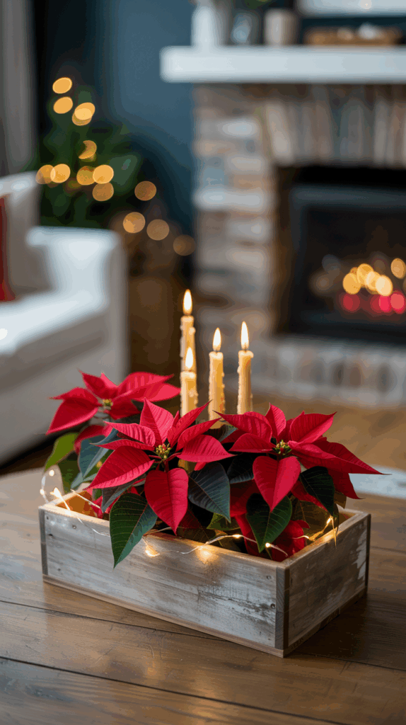 A wooden box on a wooden table holds red poinsettias and lit candles, with fairy lights draped around it. In the background, there's a fireplace with a warm glow and soft, festive lighting against a dark wall.